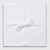 View 2 of product Three Turnbull & Asser Plain White Cotton Handkerchiefs from the 3-pack are neatly folded and overlapping on a light gray background.