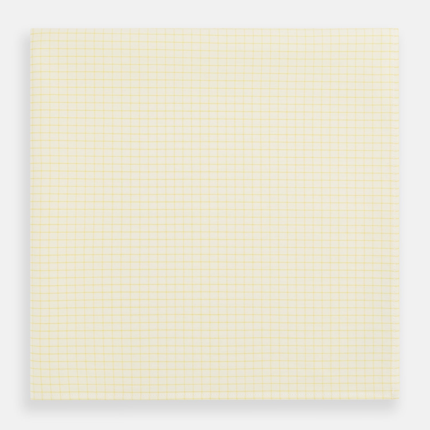 View 1 of product The Yellow Graph Check Handkerchief by Turnbull & Asser features a light yellow background with evenly spaced, thin yellow grid lines forming small squares—evoking the look of classic graph paper.
