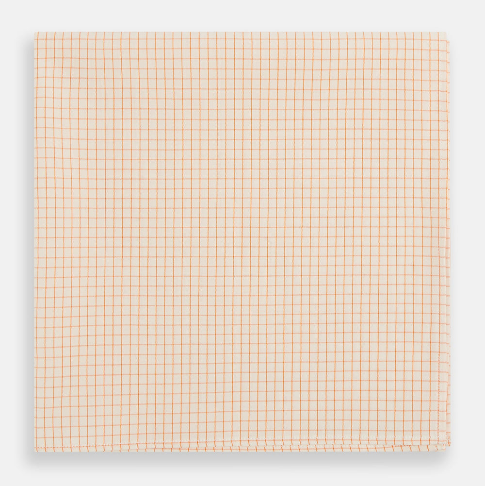 The Turnbull & Asser Orange Graph Check Handkerchief features a square cotton design with an orange and white graph check pattern, making it a stylish formal accessory.