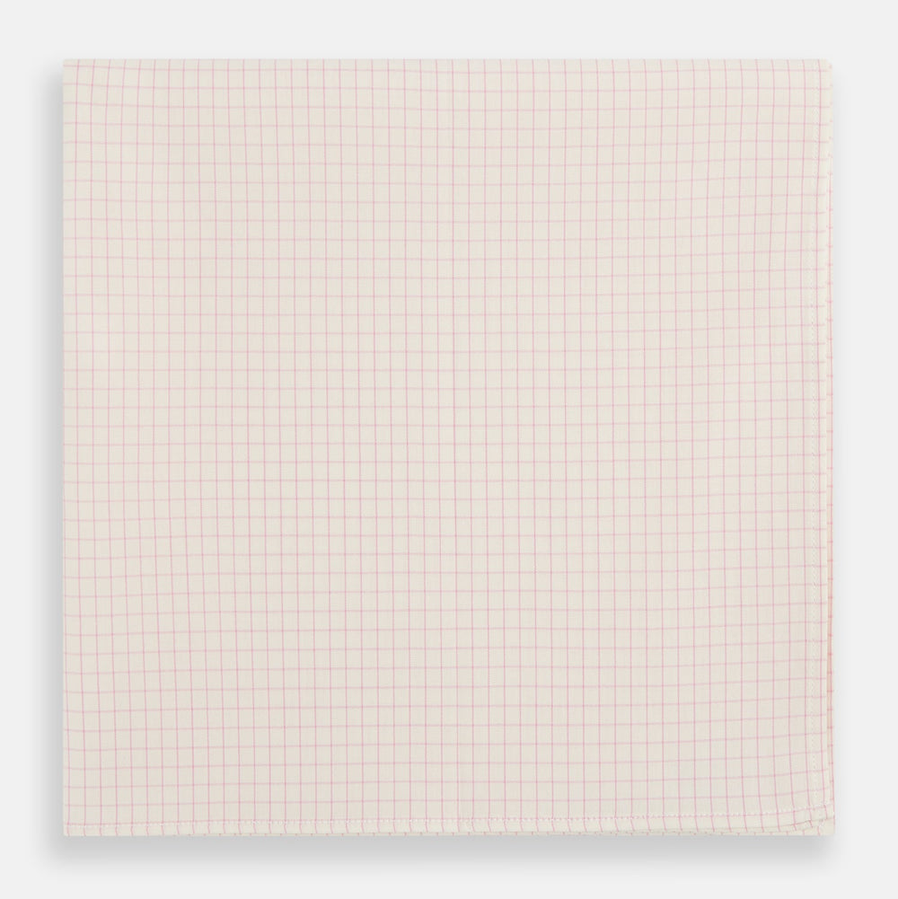 The Turnbull & Asser Pink Graph Check Handkerchief features a subtle red checkered grid on pink cotton, making it a refined formal accessory, as elegantly shown against a white background.