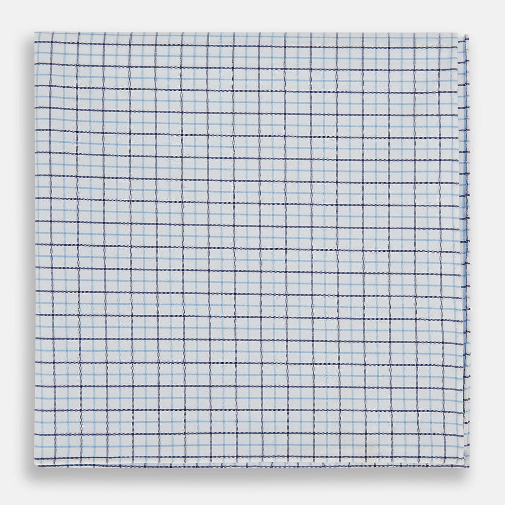 The Turnbull & Asser Hand Rolled Blue Double Graph Check Handkerchief features a cotton square with a blue and navy grid pattern, refined hand-rolled edges, and serves as an elegant gentleman's accessory.