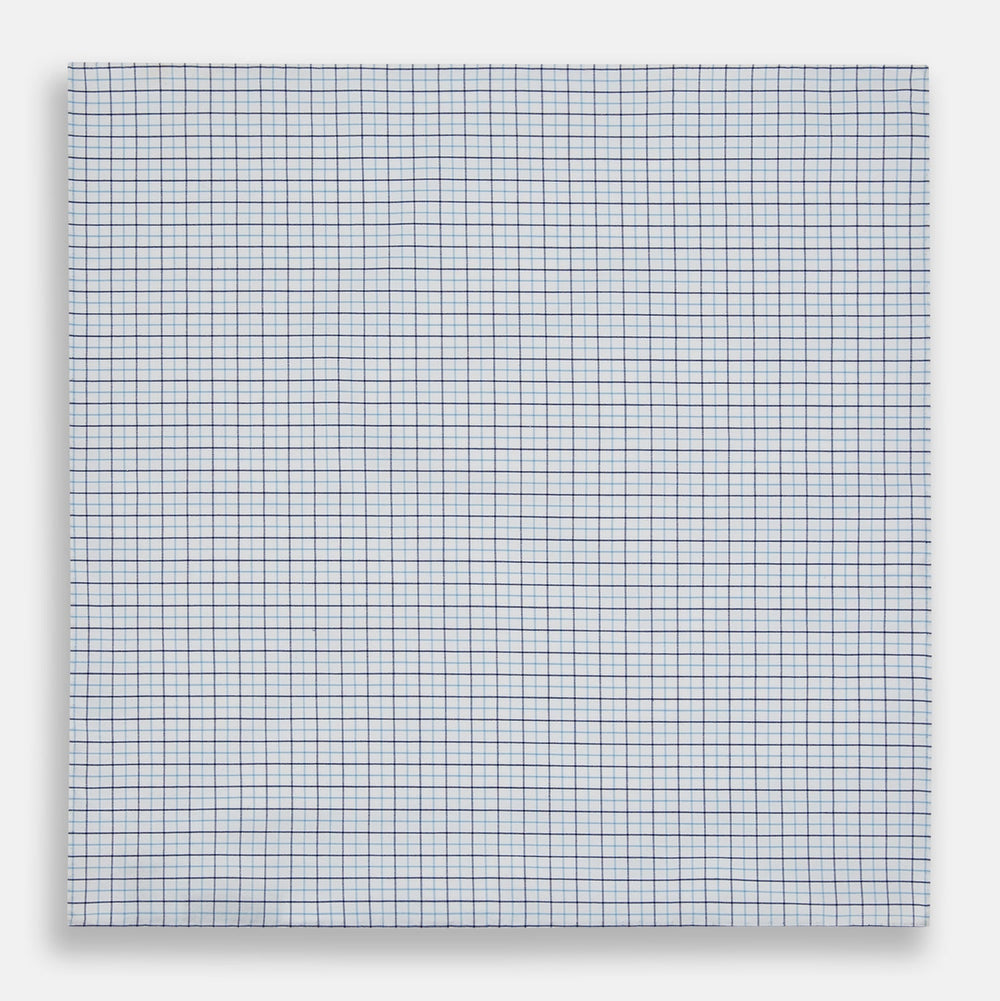 The Turnbull & Asser Hand Rolled Blue Double Graph Check Handkerchief features a cotton square with a blue and navy grid pattern, refined hand-rolled edges, and serves as an elegant gentleman's accessory.