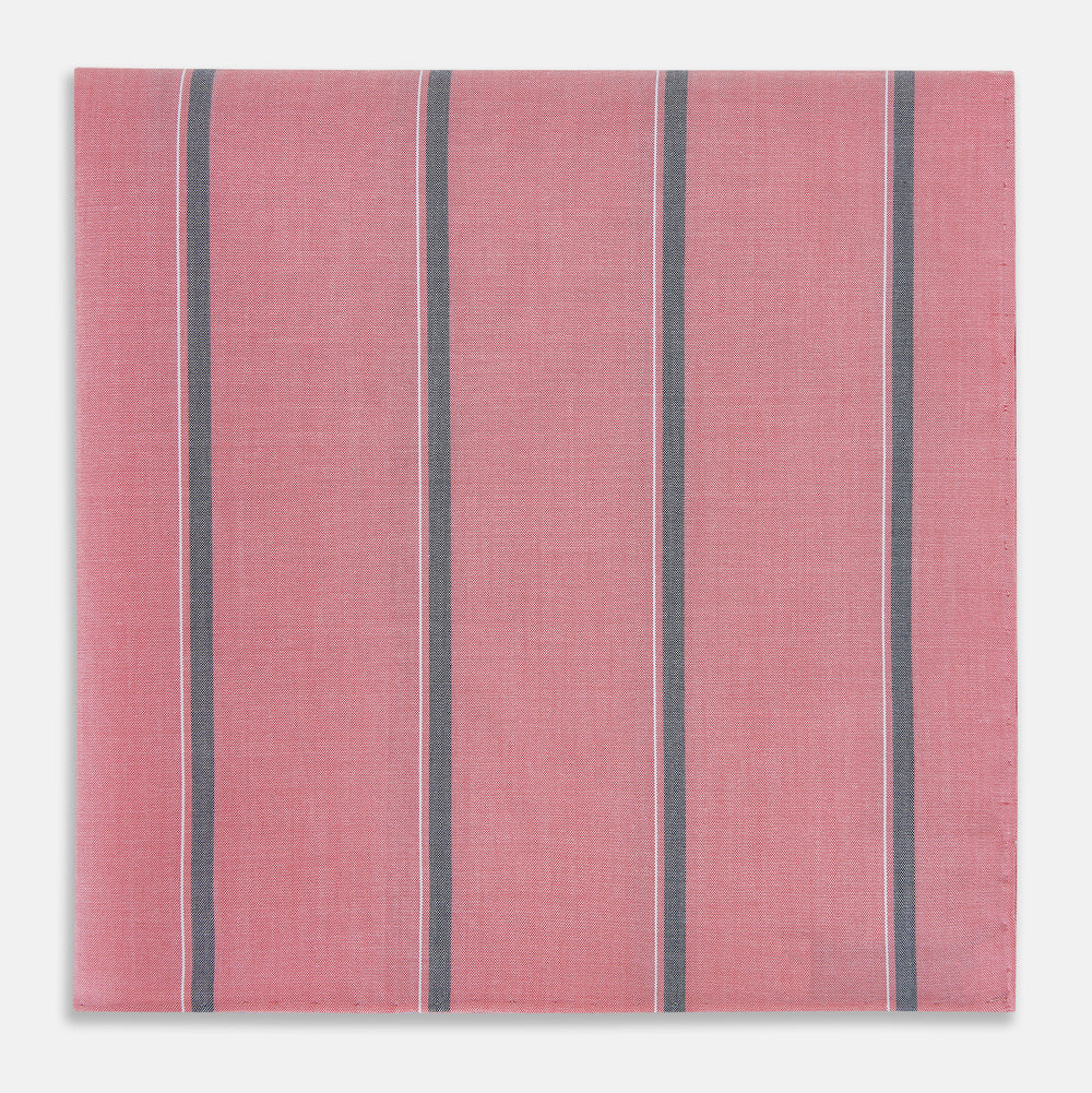 The Turnbull & Asser UK Coral Pink Track Stripe Hand-Rolled Handkerchief is a square accessory featuring evenly spaced dark gray and white vertical stripes on a coral pink background. Expertly crafted in England, it boasts elegant hand-rolled edges and is displayed against a plain white background.