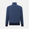 View 3 of product Introducing the Fairway Denim Golf Jacket in Linen by Turnbull & Asser UK—a blue zip-up jacket featuring a high collar, two side pockets, and a zippered chest pocket. The contrasting darker cuffs and hem accentuate its denim-like linen texture, making it the perfect versatile golf jacket for cooler days.