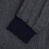 View 4 of product A front view of the Fairway Ash Golf Jacket in Linen by Turnbull & Asser UK is shown, featuring a high collar, two side zip pockets, a chest zip pocket, and black ribbed cuffs and hem. Crafted from lightweight gray herringbone linen for effortless warm-weather dressing, the jacket is displayed on a plain white background.