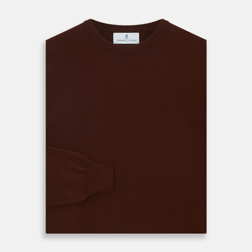 The Turnbull & Asser Port Cashmere Crew Neck Jumper, in dark brown, features a plain design with long sleeves and is shown laid flat on a white background.