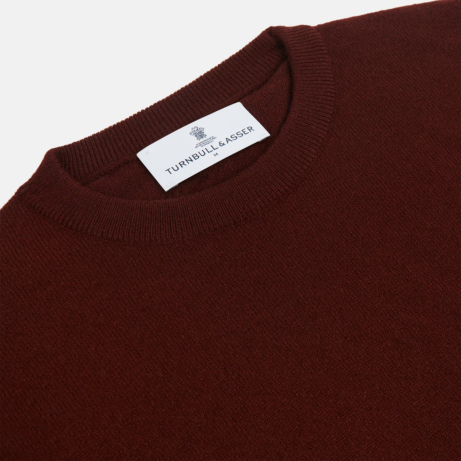 View 2 of product The Turnbull & Asser Port Cashmere Crew Neck Jumper, in dark brown, features a plain design with long sleeves and is shown laid flat on a white background.