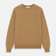 The Turnbull & Asser Camel Crew Neck Merino Wool Jumper is a classic, long-sleeve sweater in camel, laid flat on a white background. Featuring ribbed collar, cuffs, and hem, it’s an essential staple for every gentleman’s wardrobe.