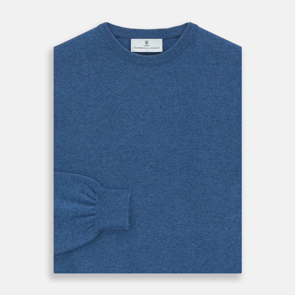 The Turnbull & Asser Blue Crew Neck Cashmere Jumper is laid flat on a white background, showcasing ribbed cuffs, hem, and neckline for an elegant, smart-casual style.