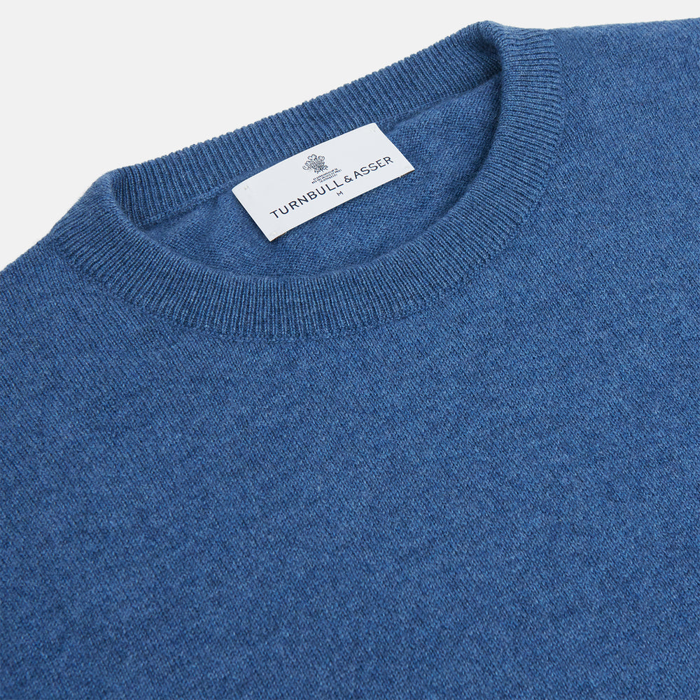The Turnbull & Asser Blue Crew Neck Cashmere Jumper is laid flat on a white background, showcasing ribbed cuffs, hem, and neckline for an elegant, smart-casual style.