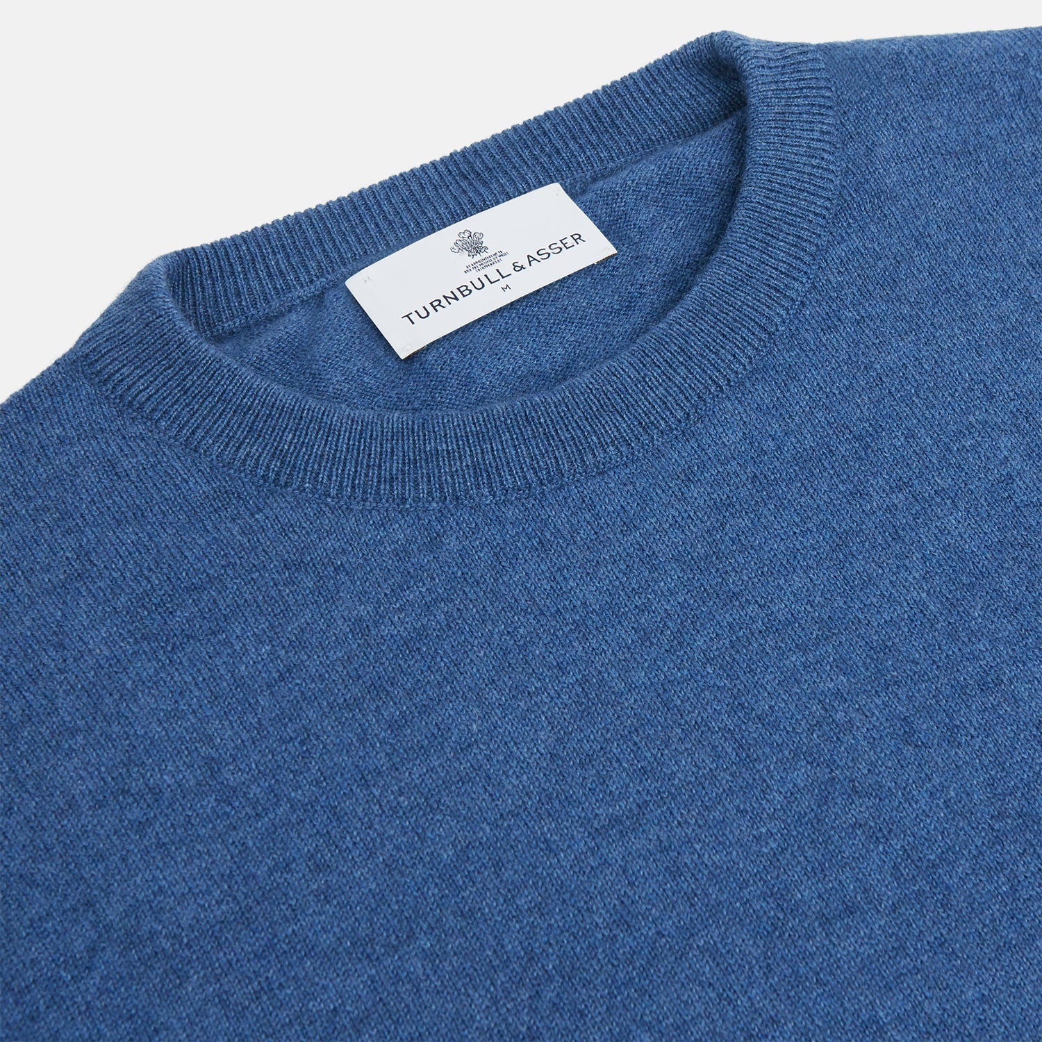 View 2 of product The Turnbull & Asser Blue Crew Neck Cashmere Jumper is laid flat on a white background, showcasing ribbed cuffs, hem, and neckline for an elegant, smart-casual style.