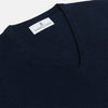 View 2 of product The Turnbull & Asser Navy V-Neck Cashmere Jumper, featuring long sleeves and ribbed cuffs and hem, is laid flat on a white background, showcasing its simple and classic design.