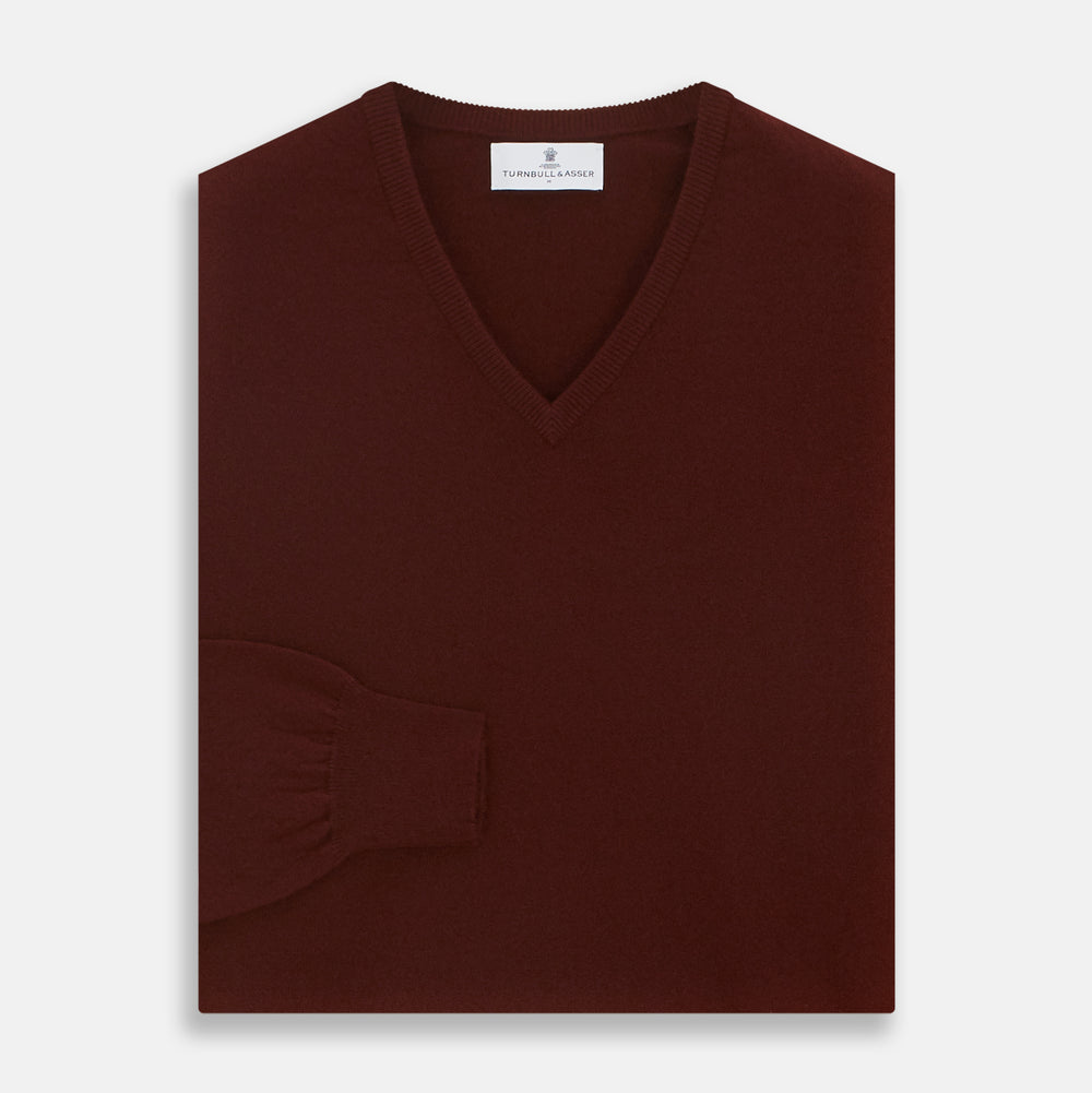 The Turnbull & Asser Port Cashmere V-Neck Jumper is a plain, long-sleeved burgundy sweater with a V-neck, shown flat on a white background.