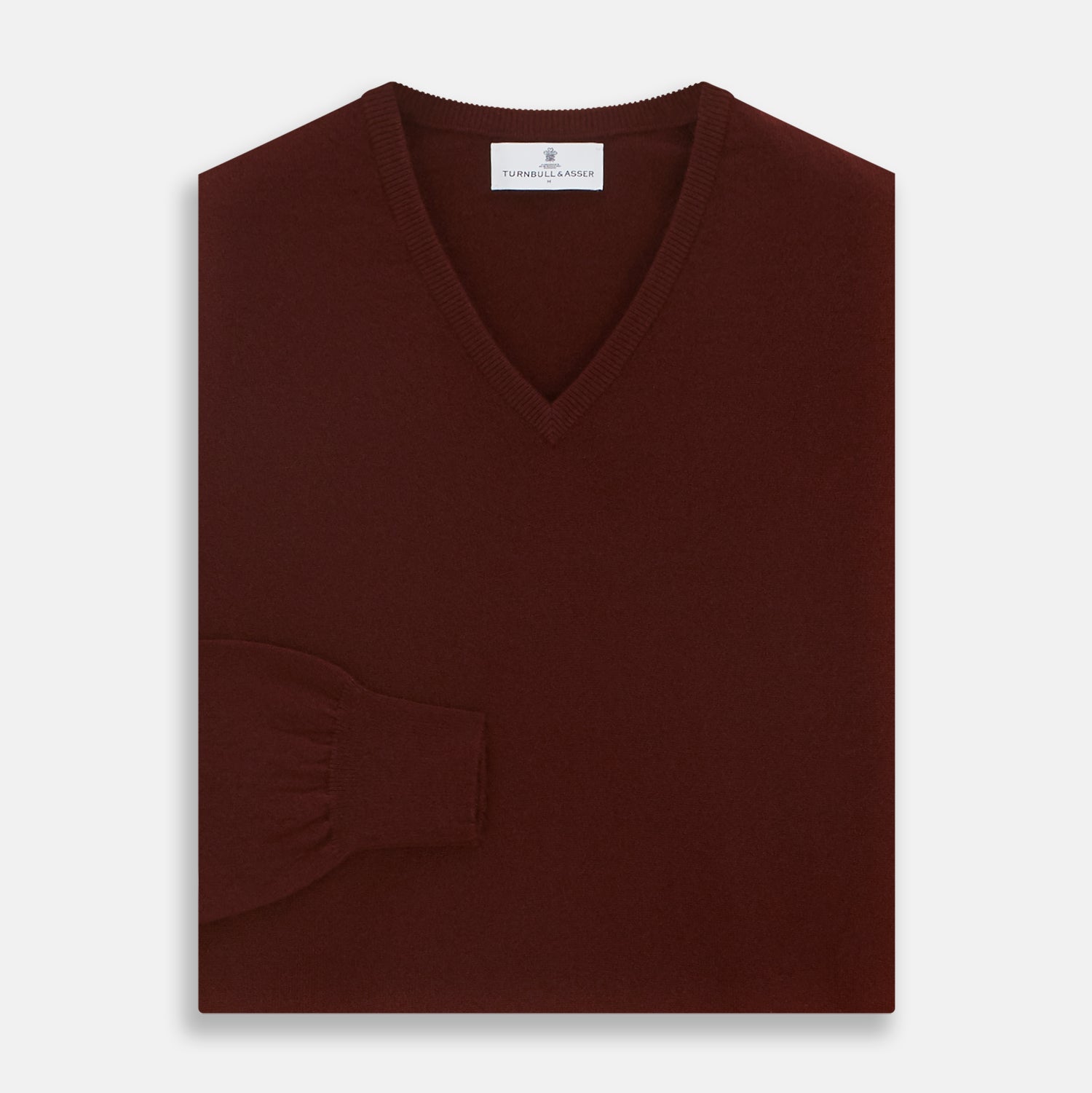 View 3 of product The Turnbull & Asser Port Cashmere V-Neck Jumper is a plain, long-sleeved burgundy sweater with a V-neck, shown flat on a white background.