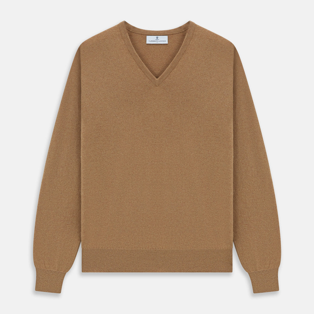 The Turnbull & Asser Natural V-Neck Cashmere Jumper, in camel, features long sleeves and ribbed cuffs, hem, and neckline. Crafted from Scottish cashmere, it’s laid flat on a white background for a refined smart casual look.