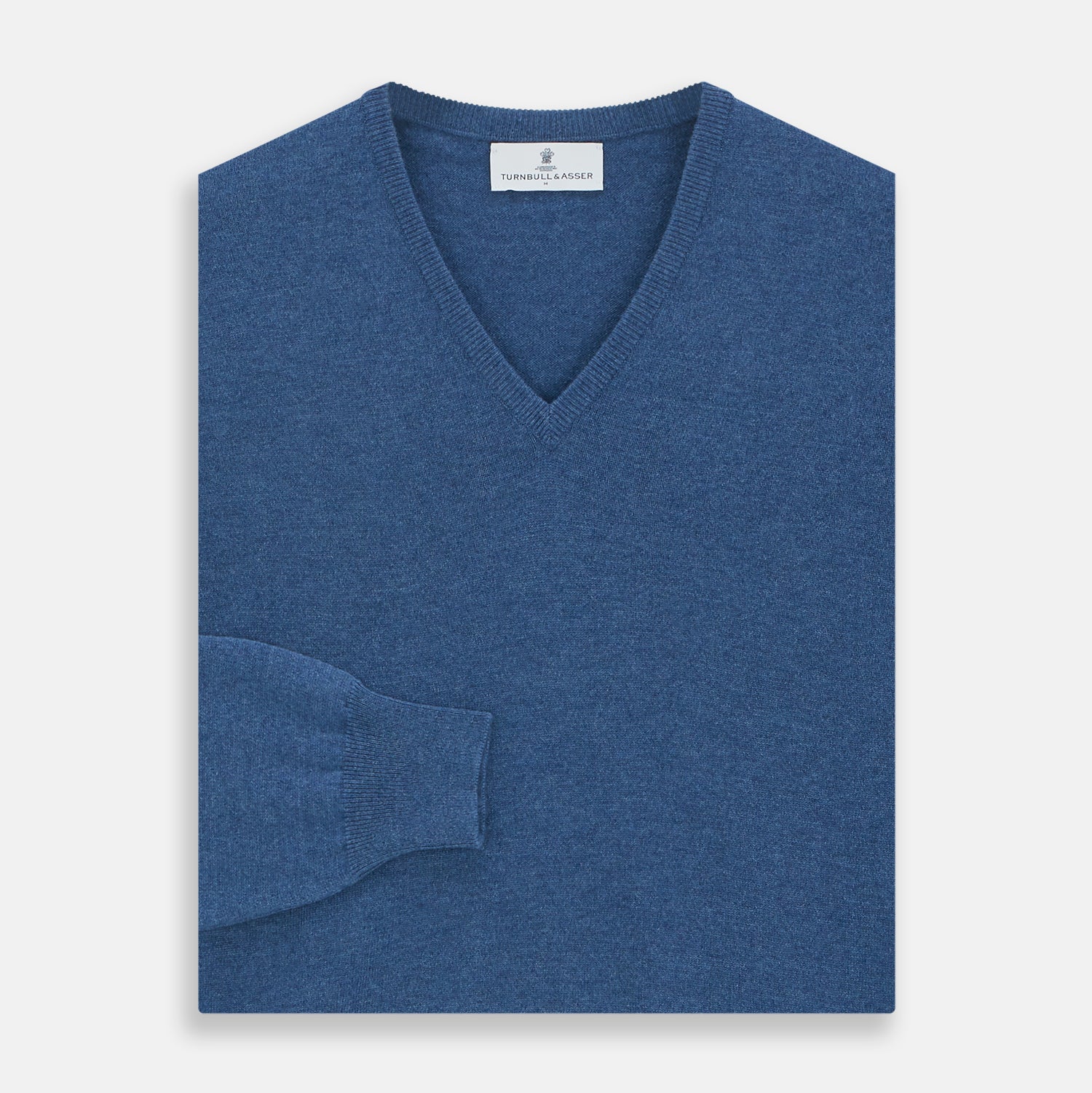 View 3 of product The Turnbull & Asser Blue V-Neck Cashmere Jumper, crafted from soft Scottish cashmere with ribbed cuffs, hem, and neckline, is shown laid flat on a white background for a refined smart-casual appeal.
