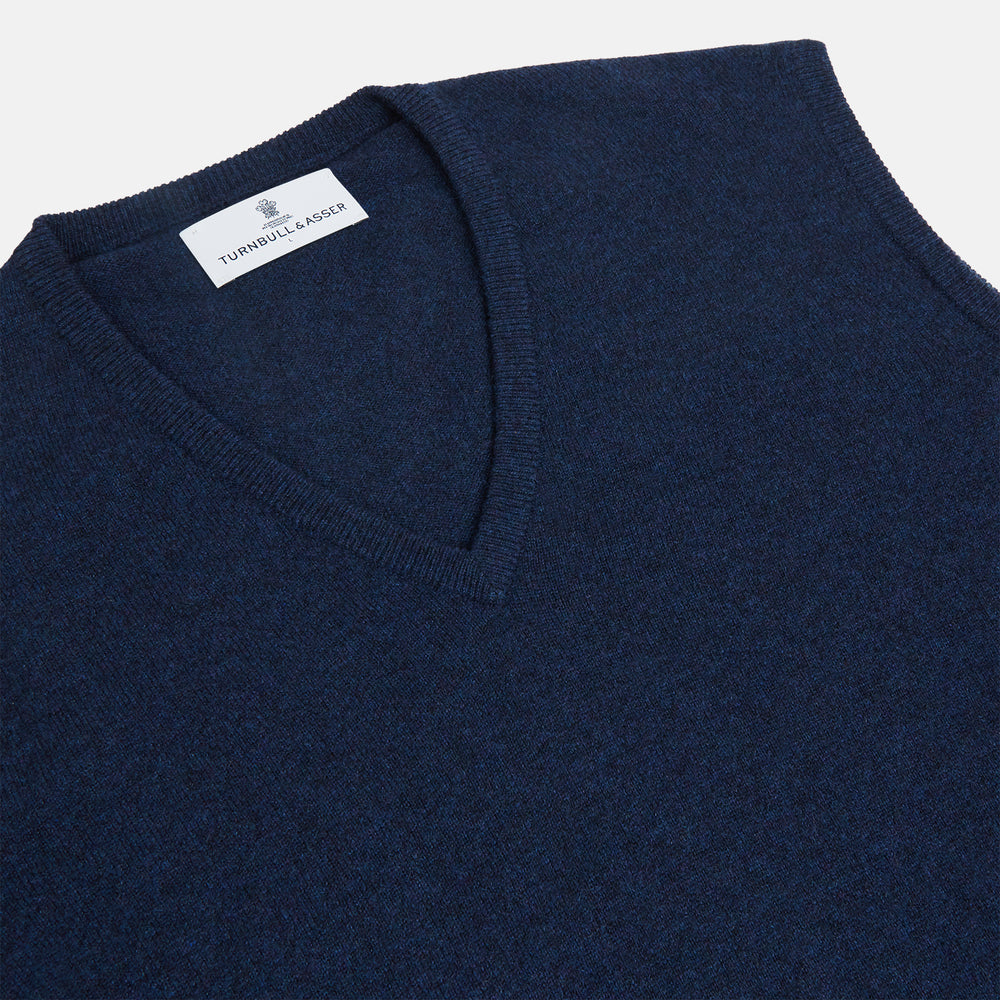 A neatly folded Turnbull & Asser Navy V-Neck Cashmere Slipover is displayed on a plain white background, its inner neckline label visible.