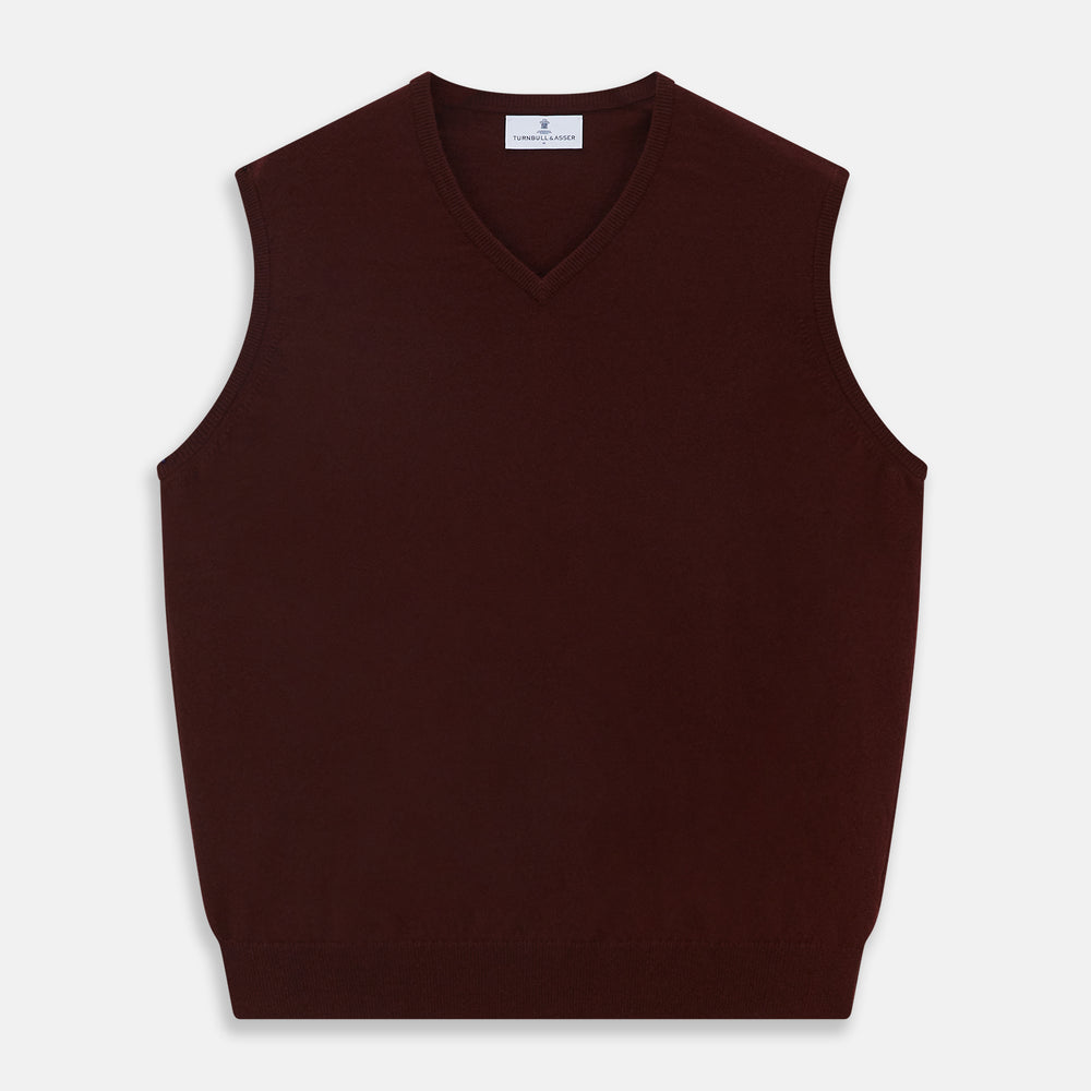 The Turnbull & Asser Port V-Neck Cashmere Slipover is a sleeveless, dark maroon vest with a simple design, shown laid flat on a white background—ideal for layering over a shirt or under a suit jacket.