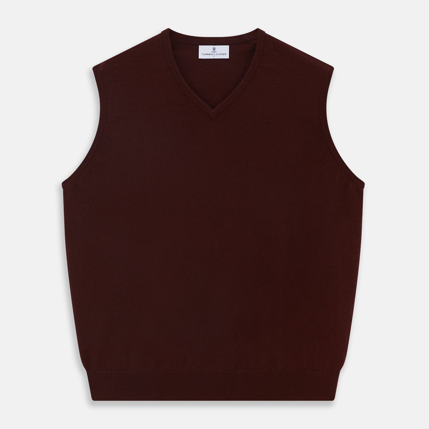 View 1 of product The Turnbull & Asser Port V-Neck Cashmere Slipover is a sleeveless, dark maroon vest with a simple design, shown laid flat on a white background—ideal for layering over a shirt or under a suit jacket.