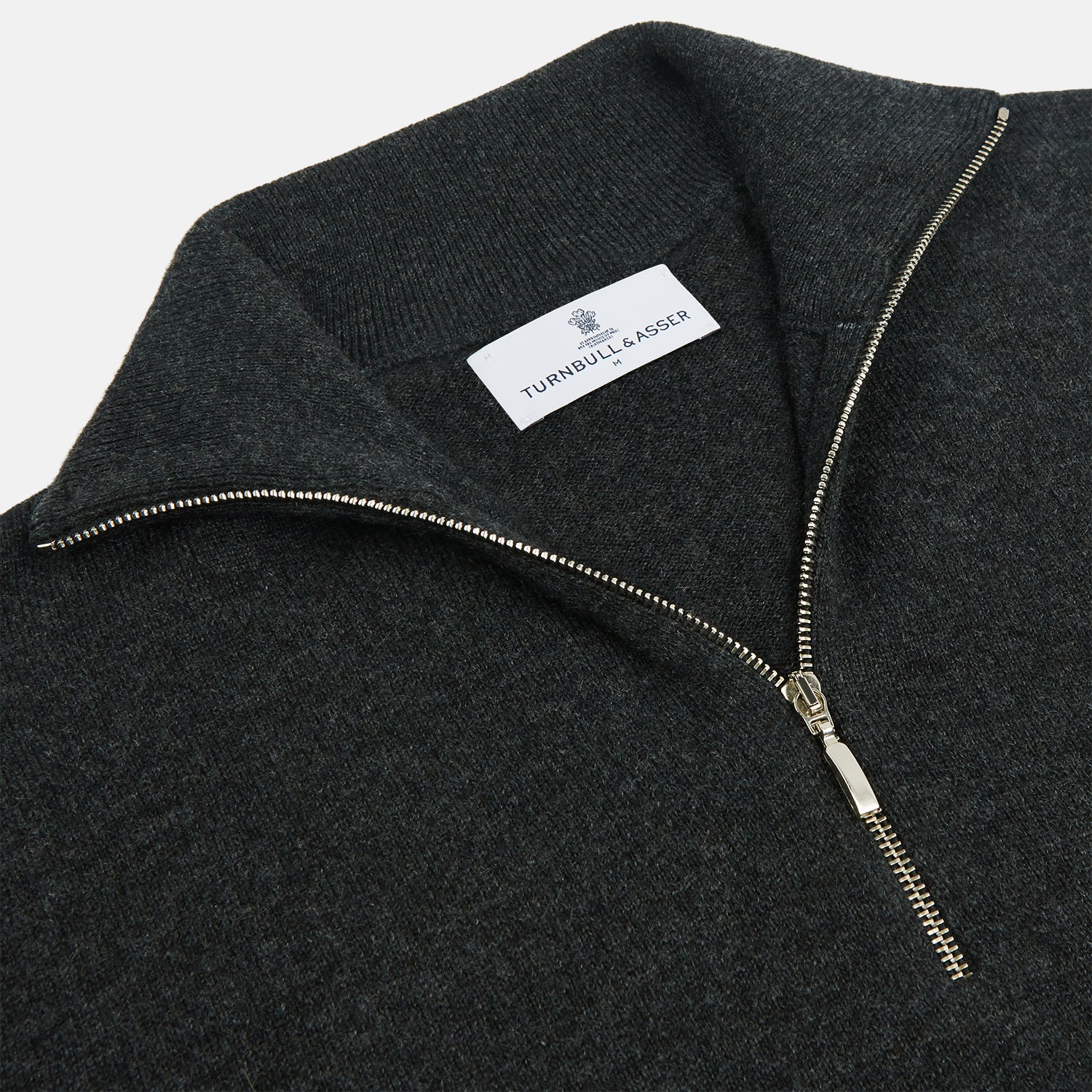 View 2 of product The Turnbull & Asser Charcoal Half-Zip Cashmere Jumper features long sleeves, a high collar, and a zip closure from the collar down the chest. Displayed flat with sleeves extended, it is crafted in dark charcoal grey cashmere.