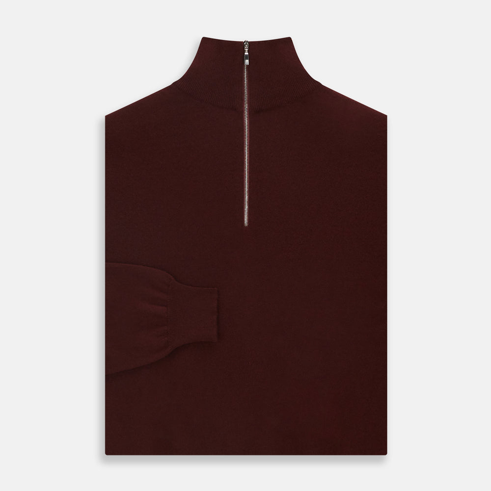 The Turnbull & Asser Port Cashmere Half-Zip Jumper is a dark maroon, long-sleeve style with a high collar, silver half-zip, and ribbed cuffs and hem, shown laid flat on a white background—ideal for layering.