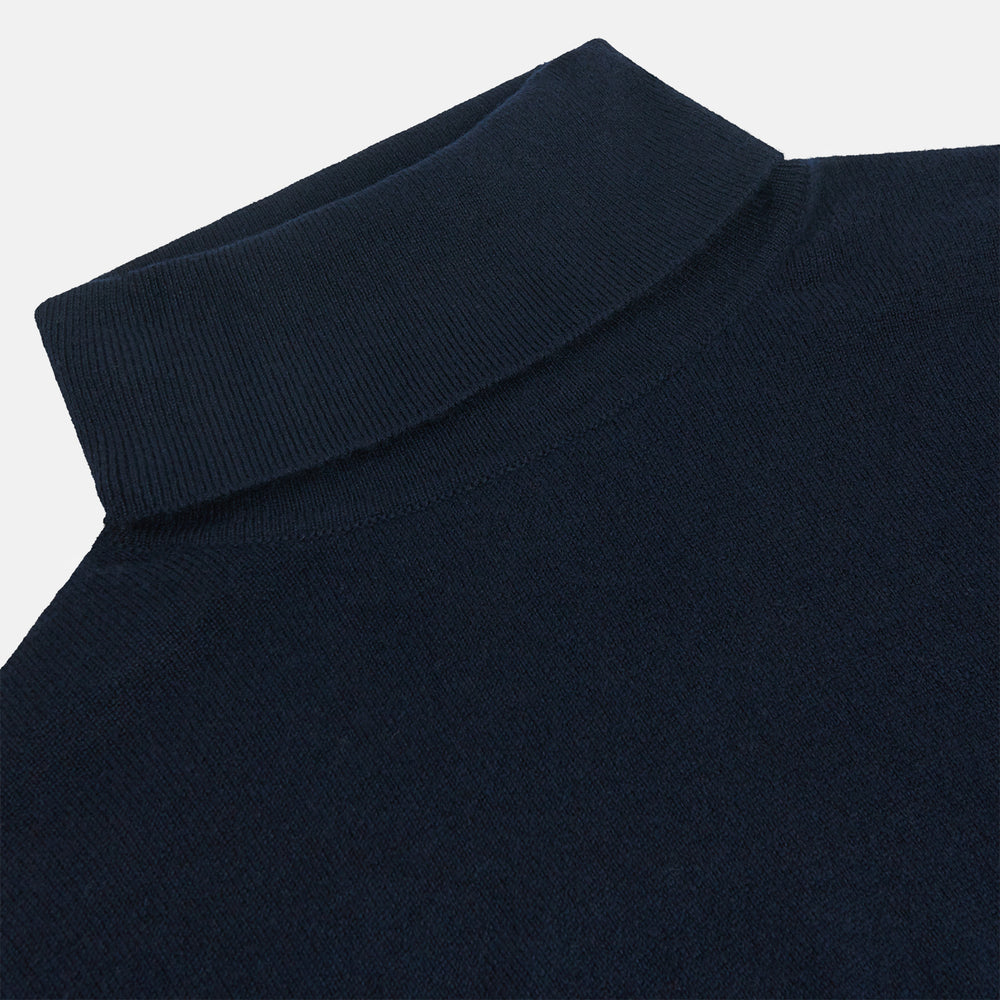 The Turnbull & Asser Navy Cashmere Roll Neck Jumper, with ribbed cuffs and hem, is a timeless autumn essential. Shown laid flat on a white background, this plain long-sleeved sweater offers classic style and comfort.