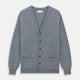 The Louis Flannel Grey Cashmere Cardigan by Turnbull & Asser features long sleeves, a V-neck, black front buttons, and two front pockets, making it ideal for transitional seasons. Shown laid flat on a white background.