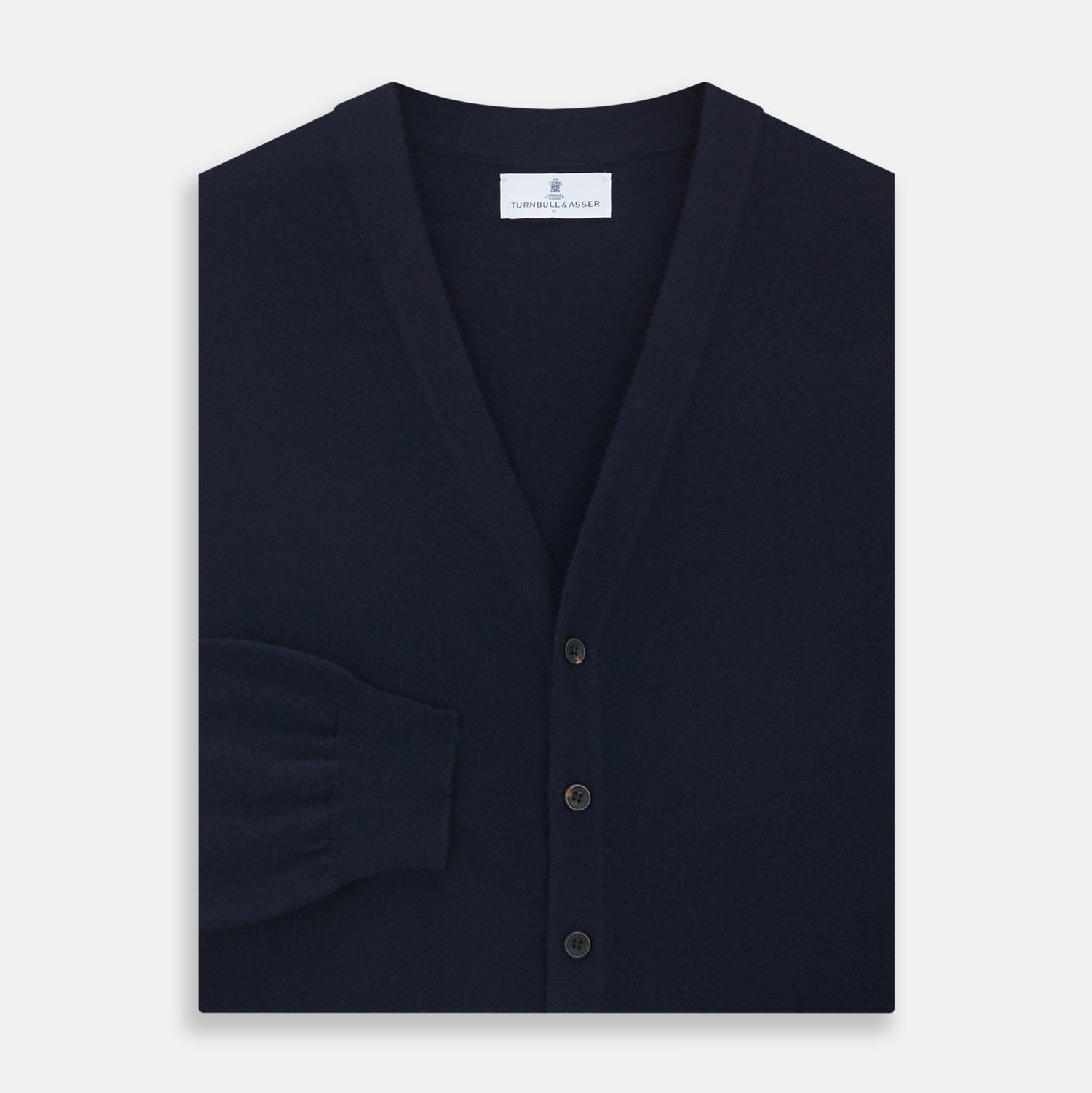 View 3 of product The Navy Cashmere Cardigan by Turnbull & Asser features long sleeves, a V-neckline, button-down front, two front pockets, and ribbed trims, crafted from 21GG cashmere in navy blue and shown laid flat on a white background.
