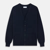 View 1 of product The Navy Cashmere Cardigan by Turnbull & Asser features long sleeves, a V-neckline, button-down front, two front pockets, and ribbed trims, crafted from 21GG cashmere in navy blue and shown laid flat on a white background.