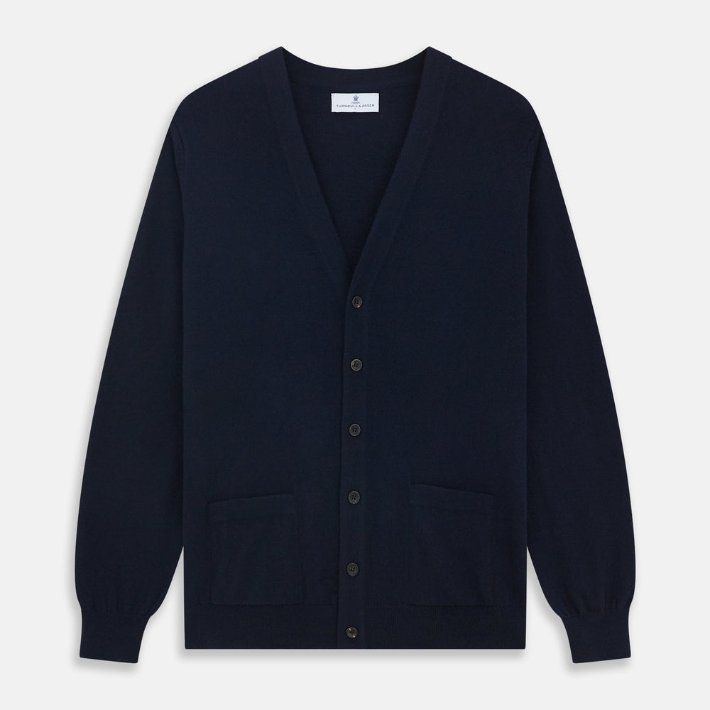 The Navy Cashmere Cardigan by Turnbull & Asser features long sleeves, a V-neckline, button-down front, two front pockets, and ribbed trims, crafted from 21GG cashmere in navy blue and shown laid flat on a white background.