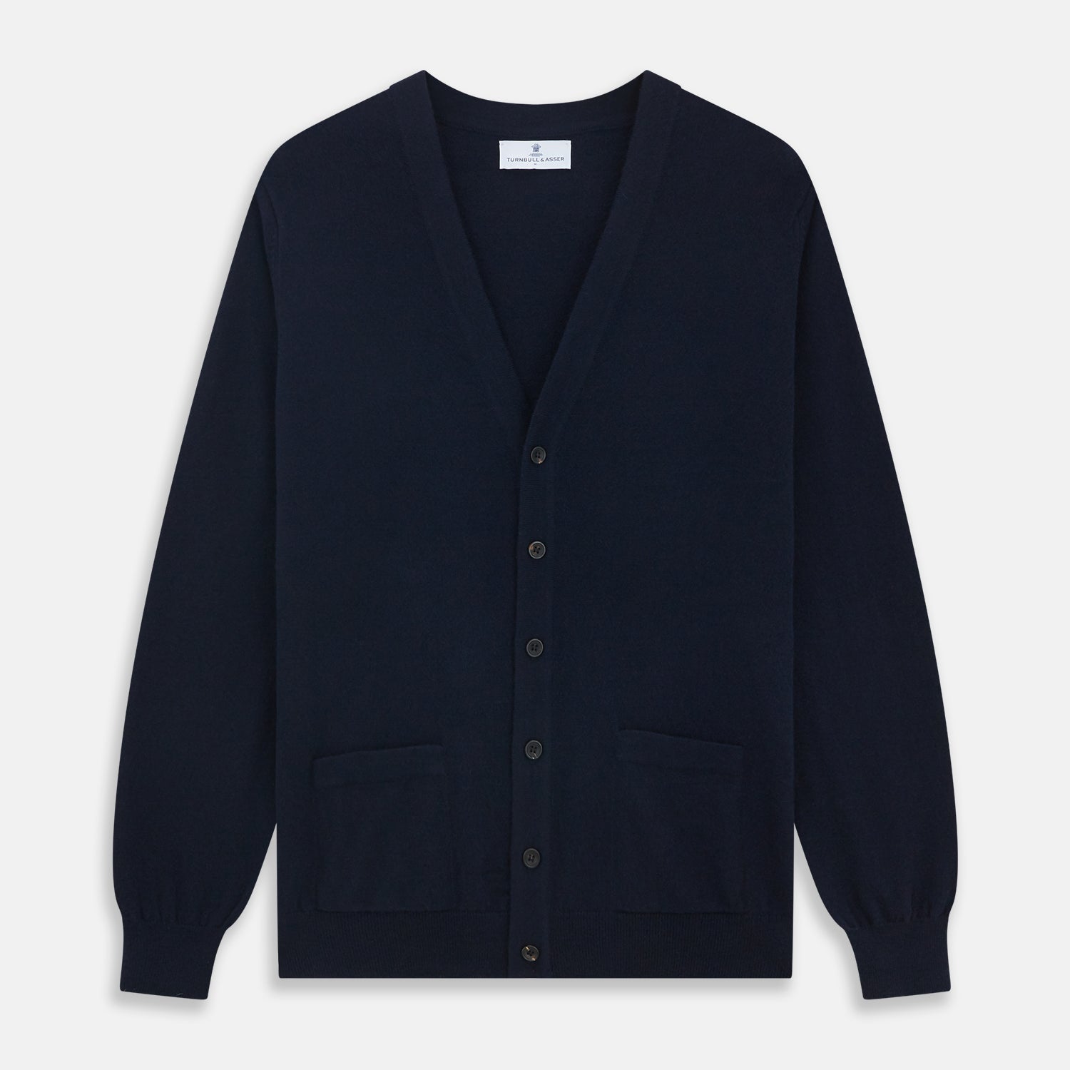 View 1 of product The Navy Cashmere Cardigan by Turnbull & Asser features long sleeves, a V-neckline, button-down front, two front pockets, and ribbed trims, crafted from 21GG cashmere in navy blue and shown laid flat on a white background.
