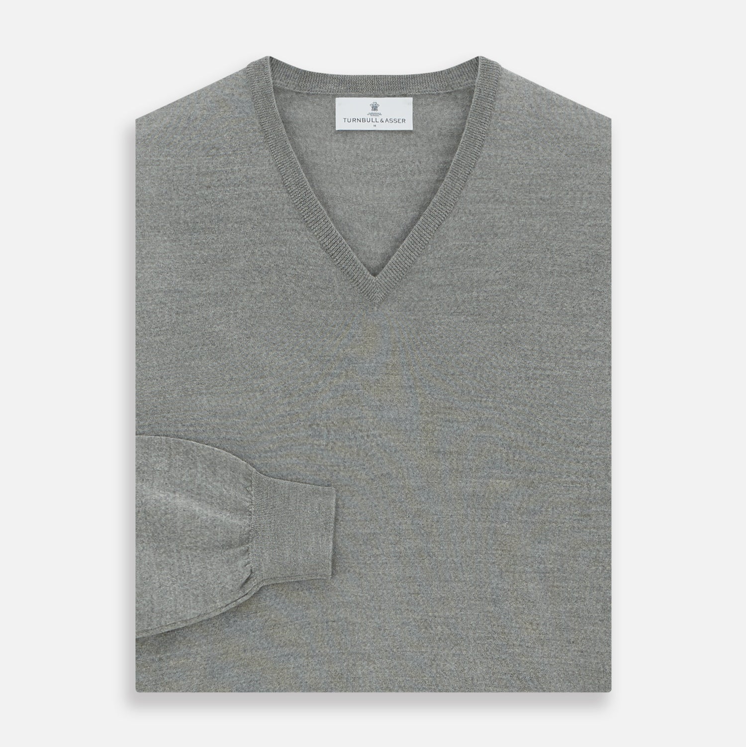 View 3 of product The Grey V-Neck Merino Wool Jumper by Turnbull & Asser features long sleeves with ribbed cuffs and hem, making it a versatile wardrobe essential for any gentleman. Shown here in classic light grey on a white background.