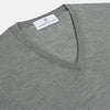View 2 of product The Grey V-Neck Merino Wool Jumper by Turnbull & Asser features long sleeves with ribbed cuffs and hem, making it a versatile wardrobe essential for any gentleman. Shown here in classic light grey on a white background.