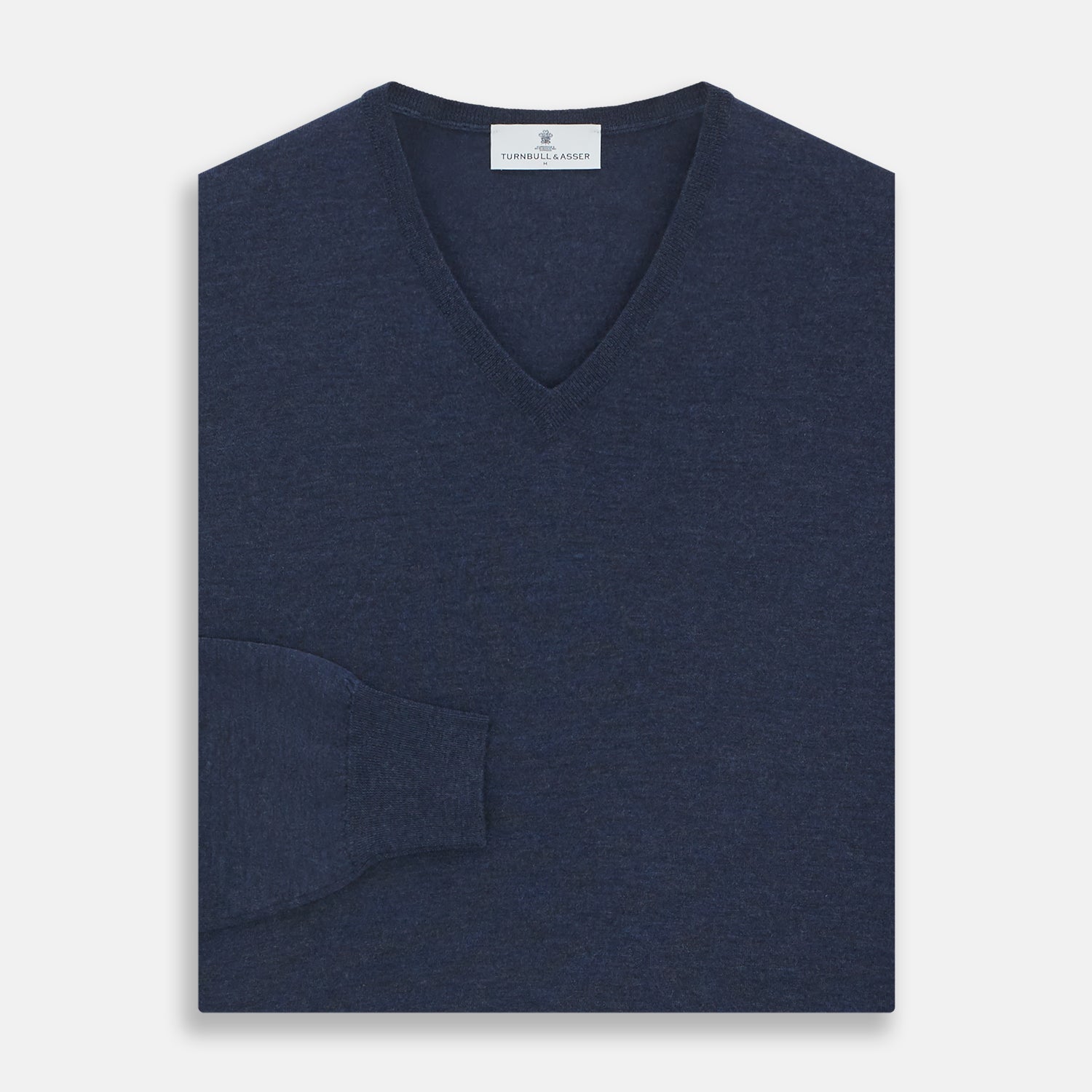 View 3 of product The Blue V-Neck Merino Wool Jumper by Turnbull & Asser features long sleeves, ribbed cuffs, and a ribbed hem—a timeless essential for any gentleman's wardrobe, shown laid flat on a white background.