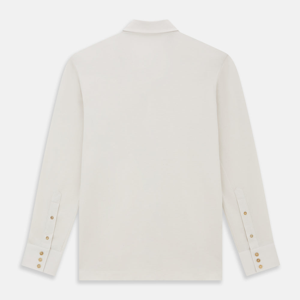 The Turnbull & Asser White Pique Shirt is a long-sleeve, white button-up with a chest pocket and beige buttons, laid flat on a white background, featuring an elevated silhouette inspired by elegant polos.