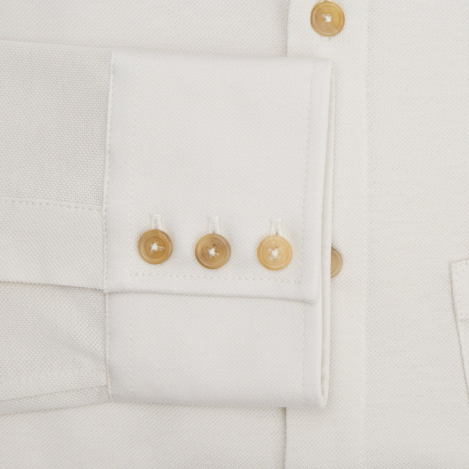 View 4 of product The Turnbull & Asser White Pique Shirt is a long-sleeve, white button-up with a chest pocket and beige buttons, laid flat on a white background, featuring an elevated silhouette inspired by elegant polos.