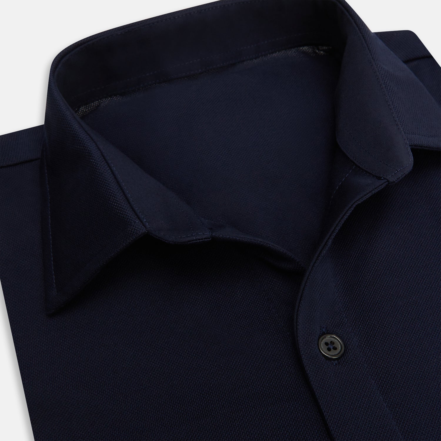 View 2 of product The Turnbull & Asser Navy Pique Shirt is a long-sleeved, dark navy button-up with a left chest pocket, classic collar, and buttoned cuffs, shown laid flat on a white background.