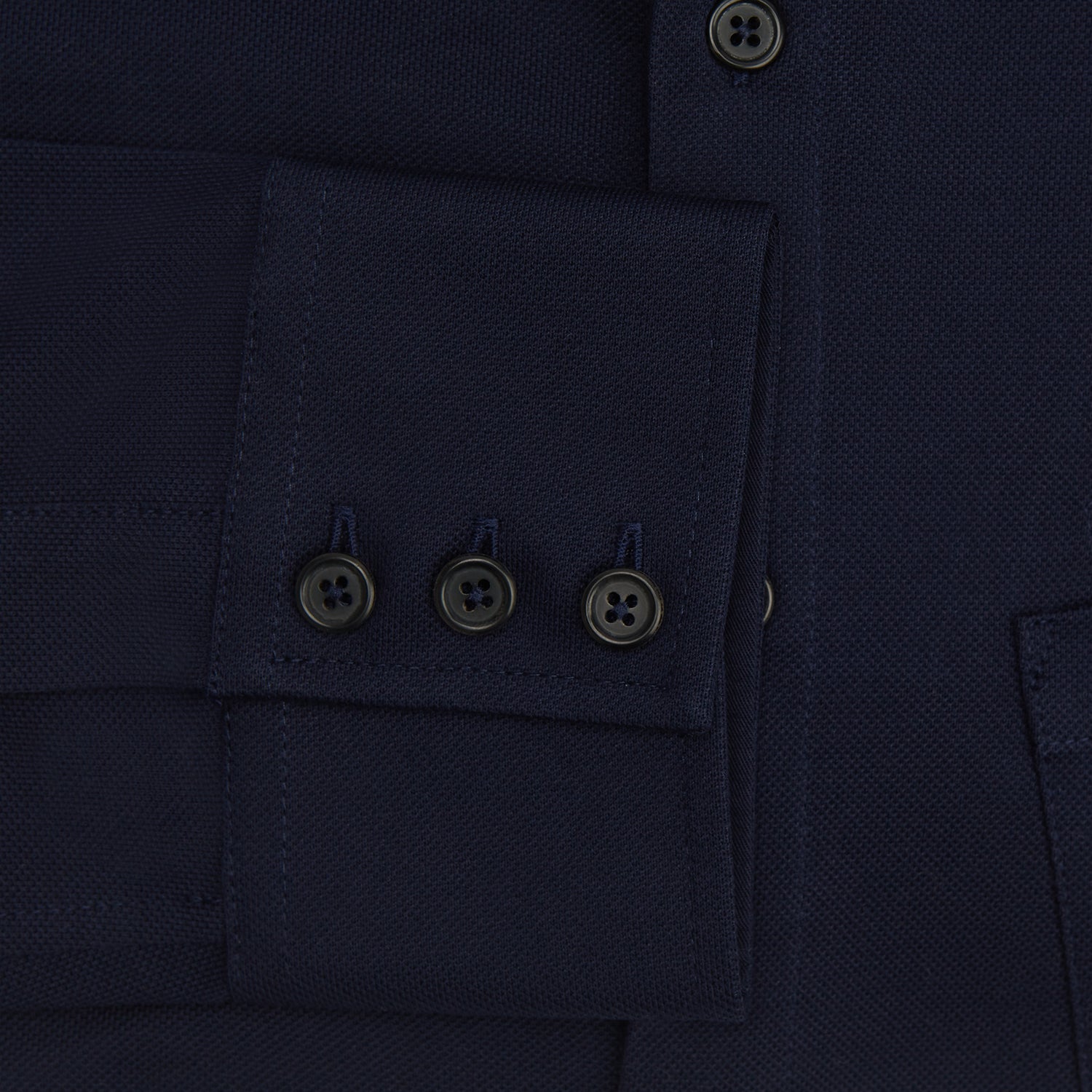 View 4 of product The Turnbull & Asser Navy Pique Shirt is a long-sleeved, dark navy button-up with a left chest pocket, classic collar, and buttoned cuffs, shown laid flat on a white background.