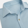 View 2 of product The Turnbull & Asser Pale Blue Pique Shirt is a long-sleeve button-up with an open collar, single chest pocket, and beige buttons, shown against a white background.