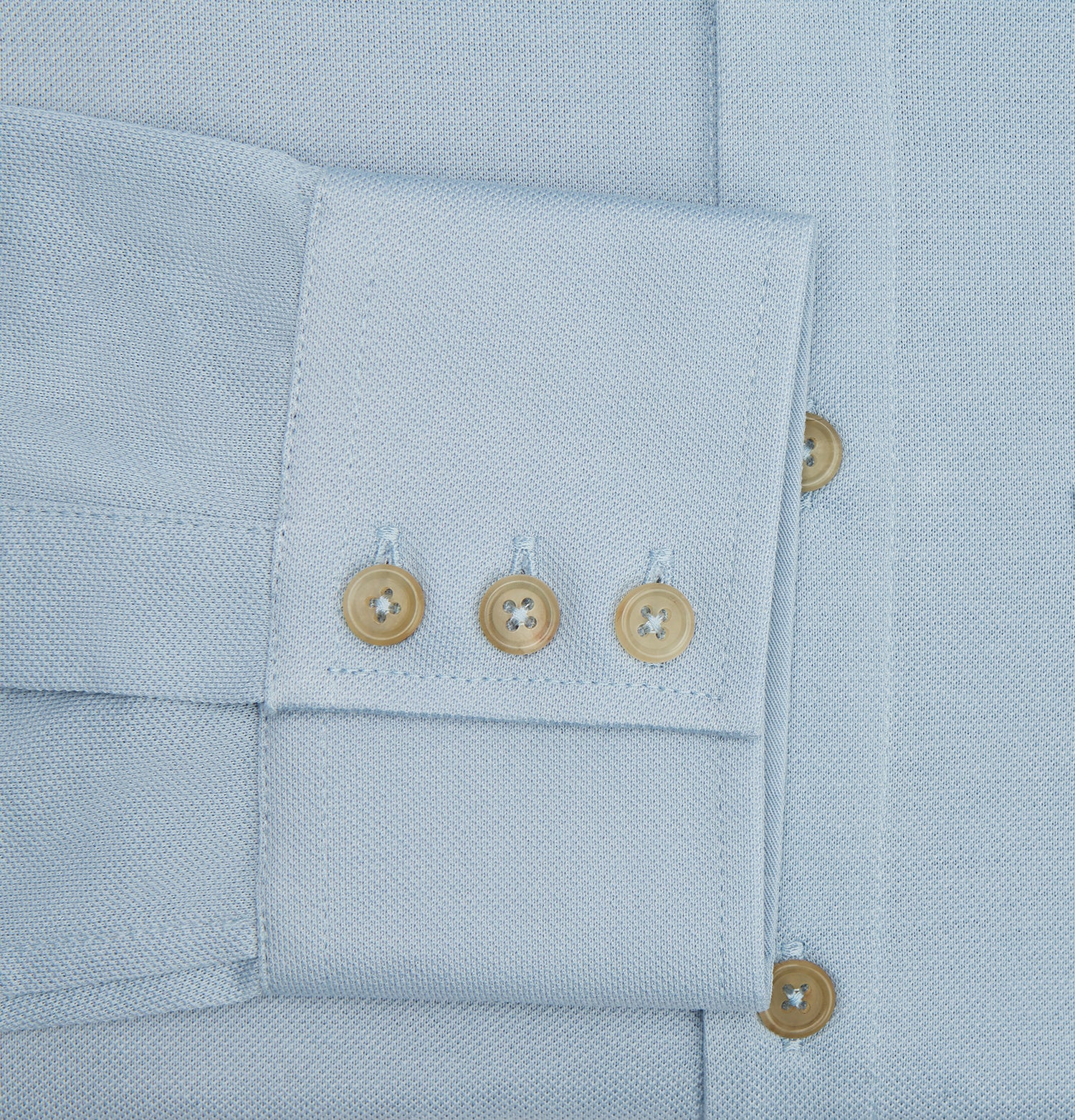 View 4 of product The Turnbull & Asser Pale Blue Pique Shirt is a long-sleeve button-up with an open collar, single chest pocket, and beige buttons, shown against a white background.