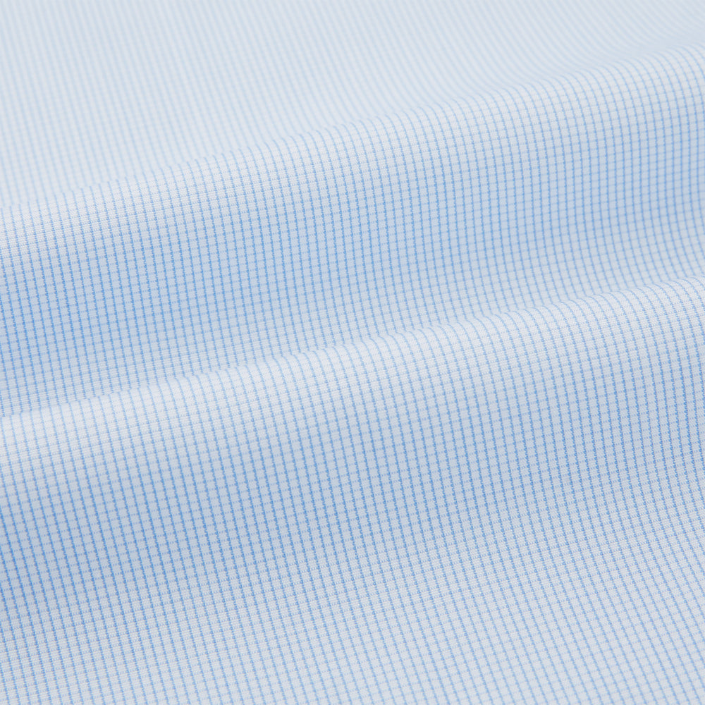 The Turnbull & Asser Pale Blue Fine Micro Check Nightshirt is a relaxed-fit, long-sleeve sleepwear piece with a collar, chest pocket, buttoned half-placket, and front pleat, shown against a plain white background.