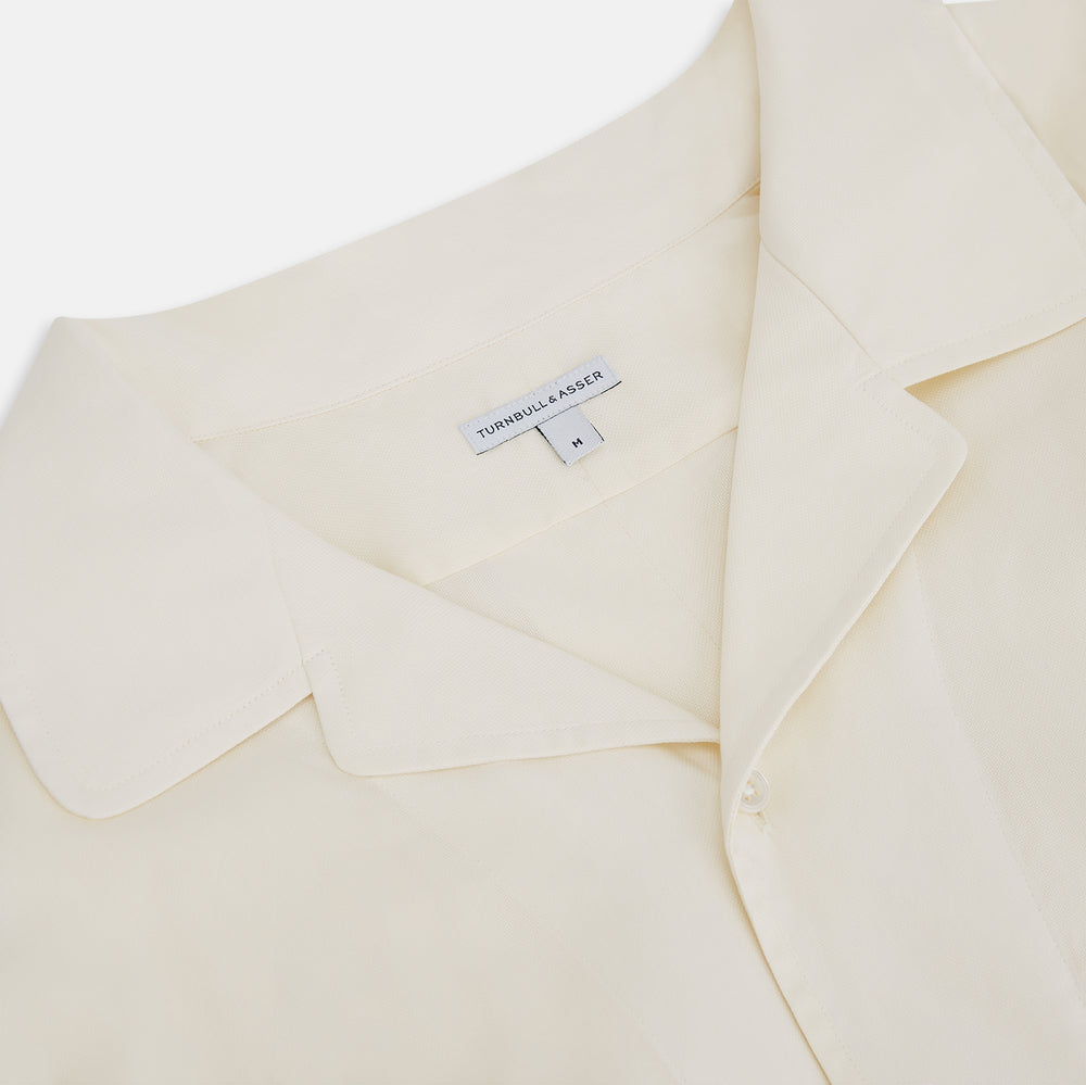 The Cream Nightshirt by Turnbull & Asser is a long-sleeved, cream-colored shirt dress with a collar, partial button front, chest pocket, and relaxed fit—ideal as comfortable sleepwear—shown on a plain white background.