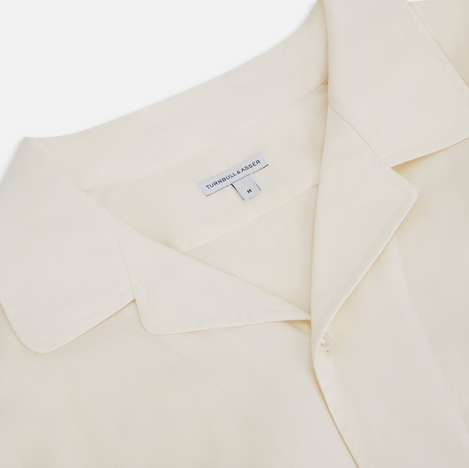 View 2 of product The Cream Nightshirt by Turnbull & Asser is a long-sleeved, cream-colored shirt dress with a collar, partial button front, chest pocket, and relaxed fit—ideal as comfortable sleepwear—shown on a plain white background.