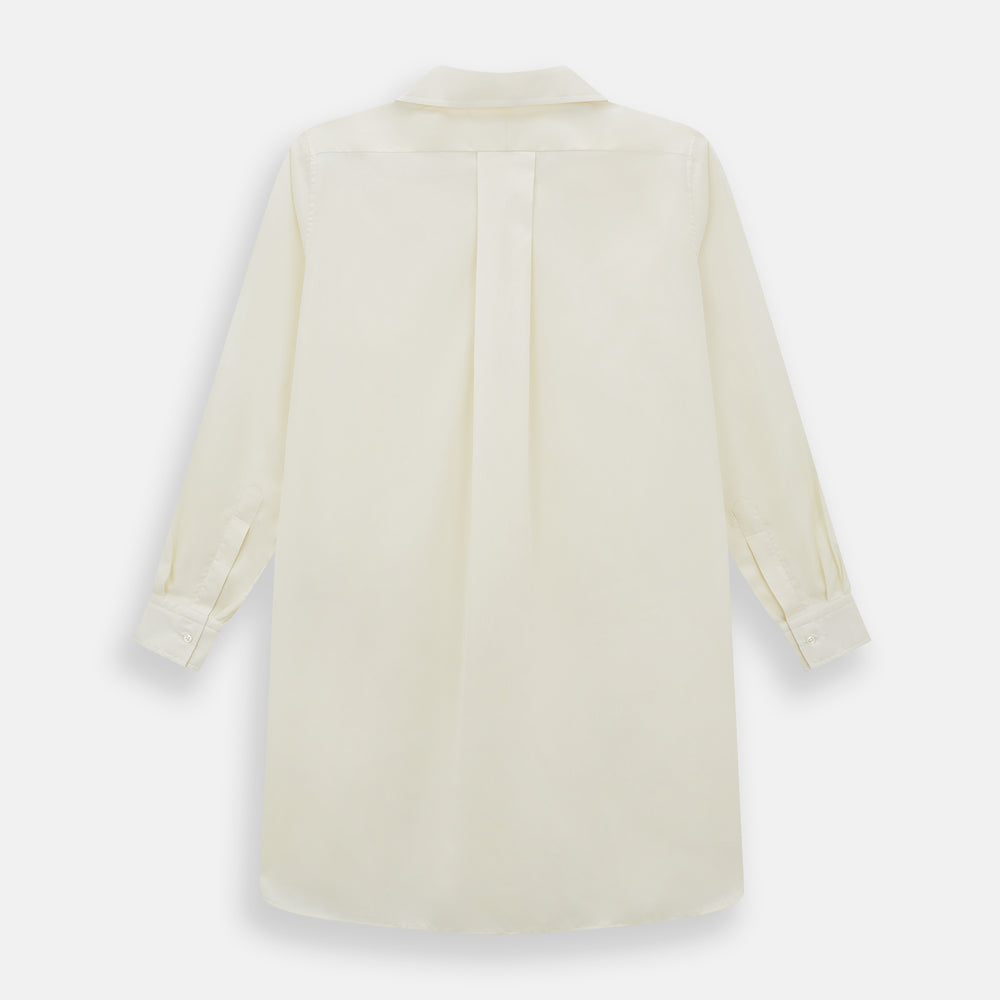 The Cream Nightshirt by Turnbull & Asser is a long-sleeved, cream-colored shirt dress with a collar, partial button front, chest pocket, and relaxed fit—ideal as comfortable sleepwear—shown on a plain white background.