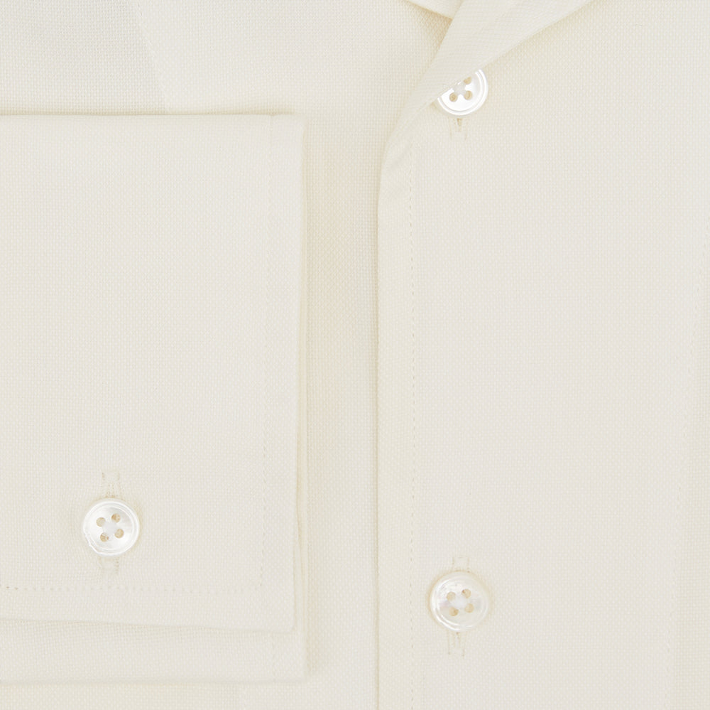 The Cream Nightshirt by Turnbull & Asser is a long-sleeved, cream-colored shirt dress with a collar, partial button front, chest pocket, and relaxed fit—ideal as comfortable sleepwear—shown on a plain white background.