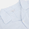 View 2 of product The Turnbull & Asser Pale Blue Bengal Stripe Nightshirt features light blue and white vertical stripes, a collar, chest pocket, and upper front buttons—perfect relaxing sleepwear, shown on a white background.