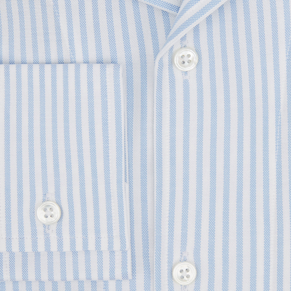 The Turnbull & Asser Pale Blue Bengal Stripe Nightshirt features light blue and white vertical stripes, a collar, chest pocket, and upper front buttons—perfect relaxing sleepwear, shown on a white background.