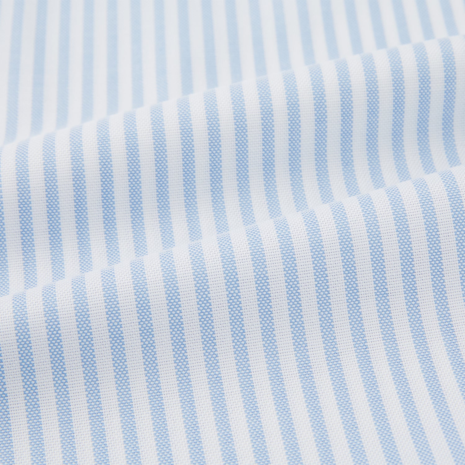 View 5 of product The Turnbull & Asser Pale Blue Bengal Stripe Nightshirt features light blue and white vertical stripes, a collar, chest pocket, and upper front buttons—perfect relaxing sleepwear, shown on a white background.