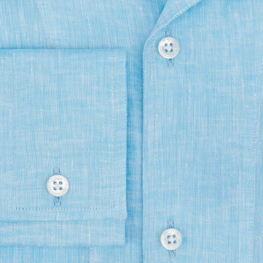 The Turnbull & Asser Turquoise Linen Nightshirt features long sleeves, a collar, button placket, single chest pocket, and a loose fit. Shown in light blue on a plain white background.