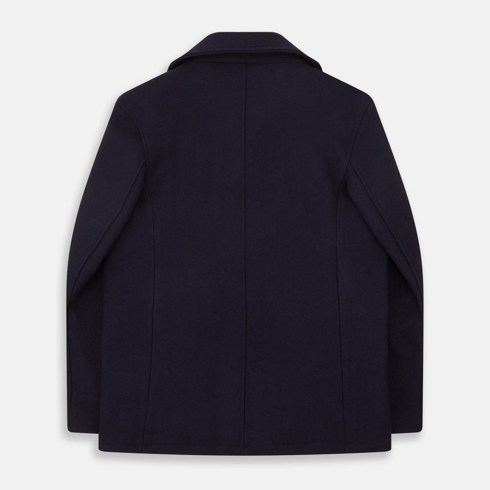 The Navy Lambswool Redford Peacoat by Turnbull & Asser is a double-breasted navy outerwear with black buttons, broad lapels, slanted pockets, and a striking deep red inner lining.